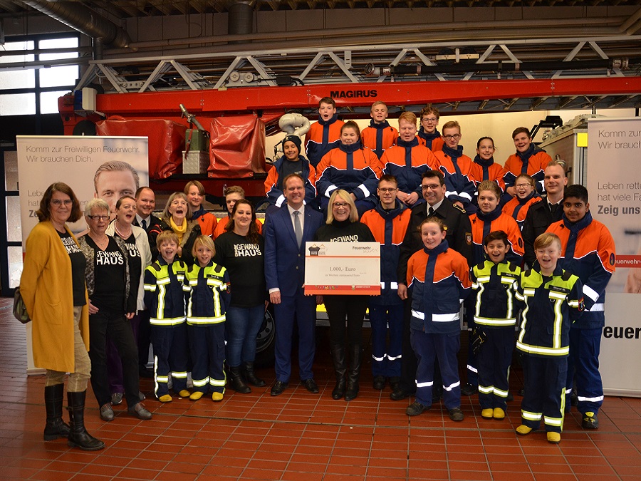 Im Beisein von Mitgliedern der "MINIS" und der Jugendfeuerwehr sowie von Feuerwehrchef Michael Mund nahm Bürgermeister Dirk Breuer von Lisa Hackenjos (Mitte vorn) einen Scheck entgegen. Foto: Pütz